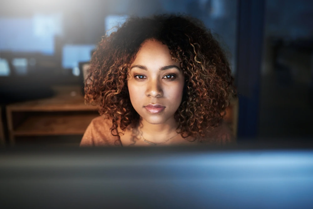 Editorial desk with stacked newspapers, reading glasses, an open notebook, and a magnifying glass resting on a printed article